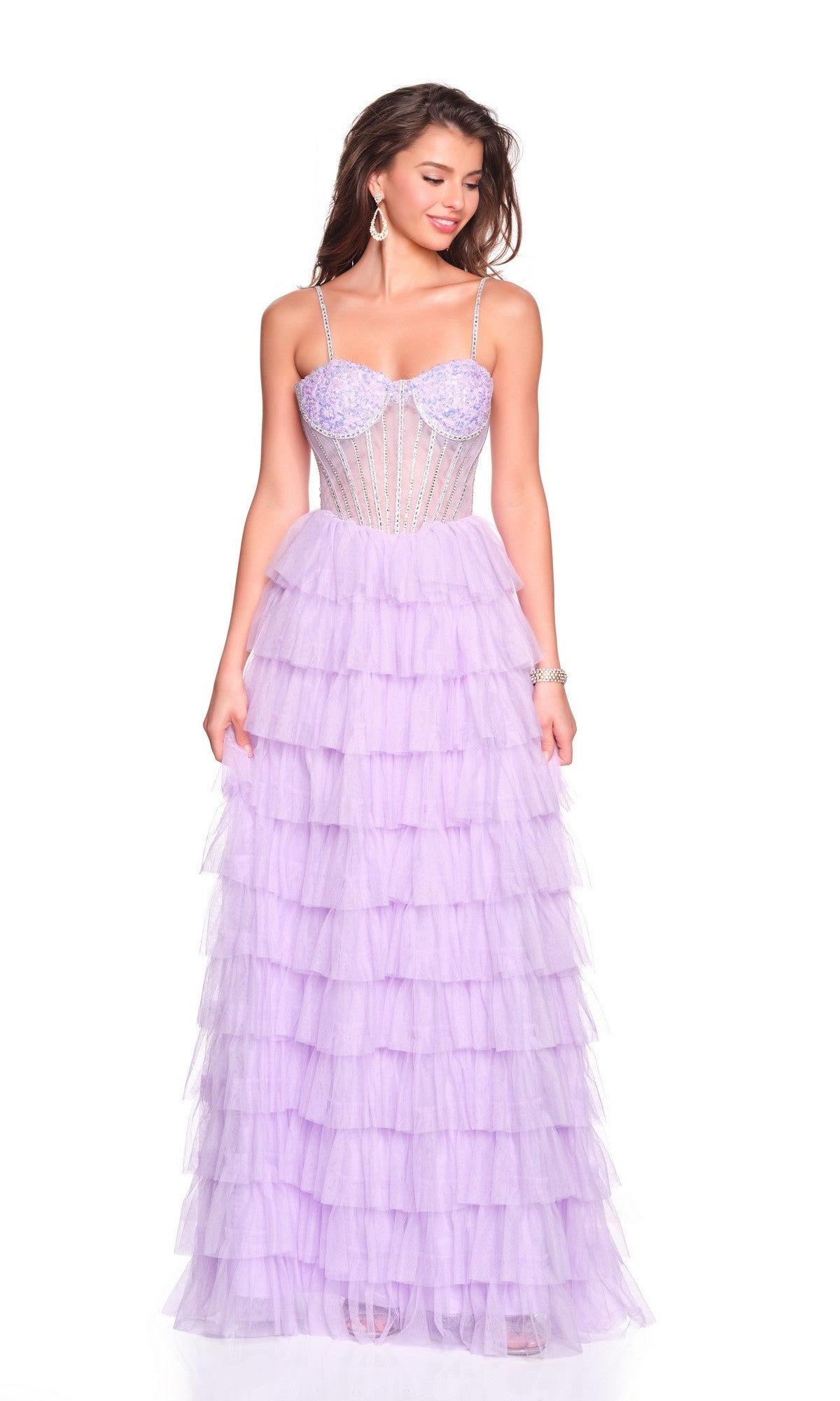 A woman wears the Dave and Johnny 12690 long prom dress, featuring light purple tiered tulle, an a-line skirt, and a fitted beaded bodice with spaghetti straps, standing against a white background.